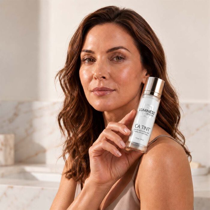 Woman holding LUMINESS CA Tint Color Adjusting Tinted Moisturizer for a natural radiant finish